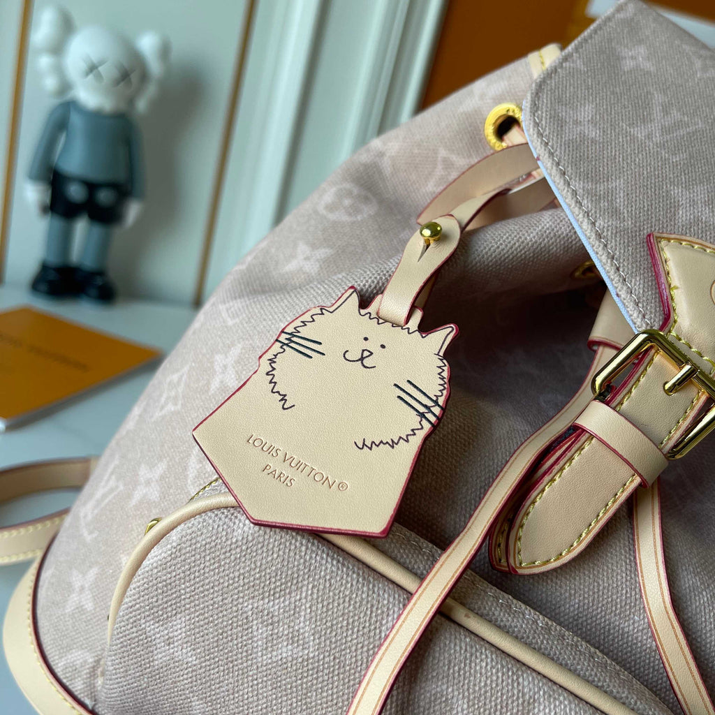 Louis Vuitton handbag with a cat-shaped tag on a blurred indoor background