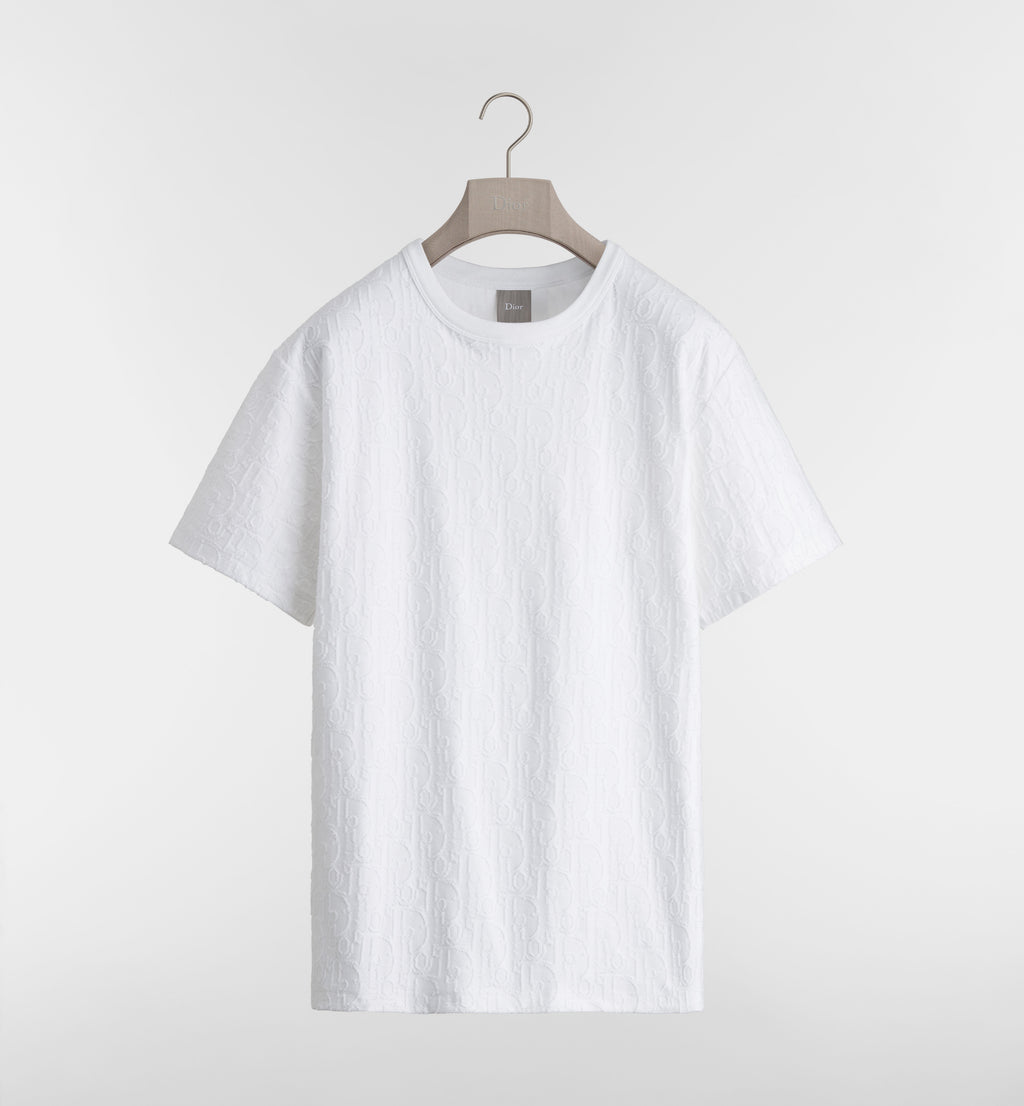 White t-shirt on a hanger against a light gray background