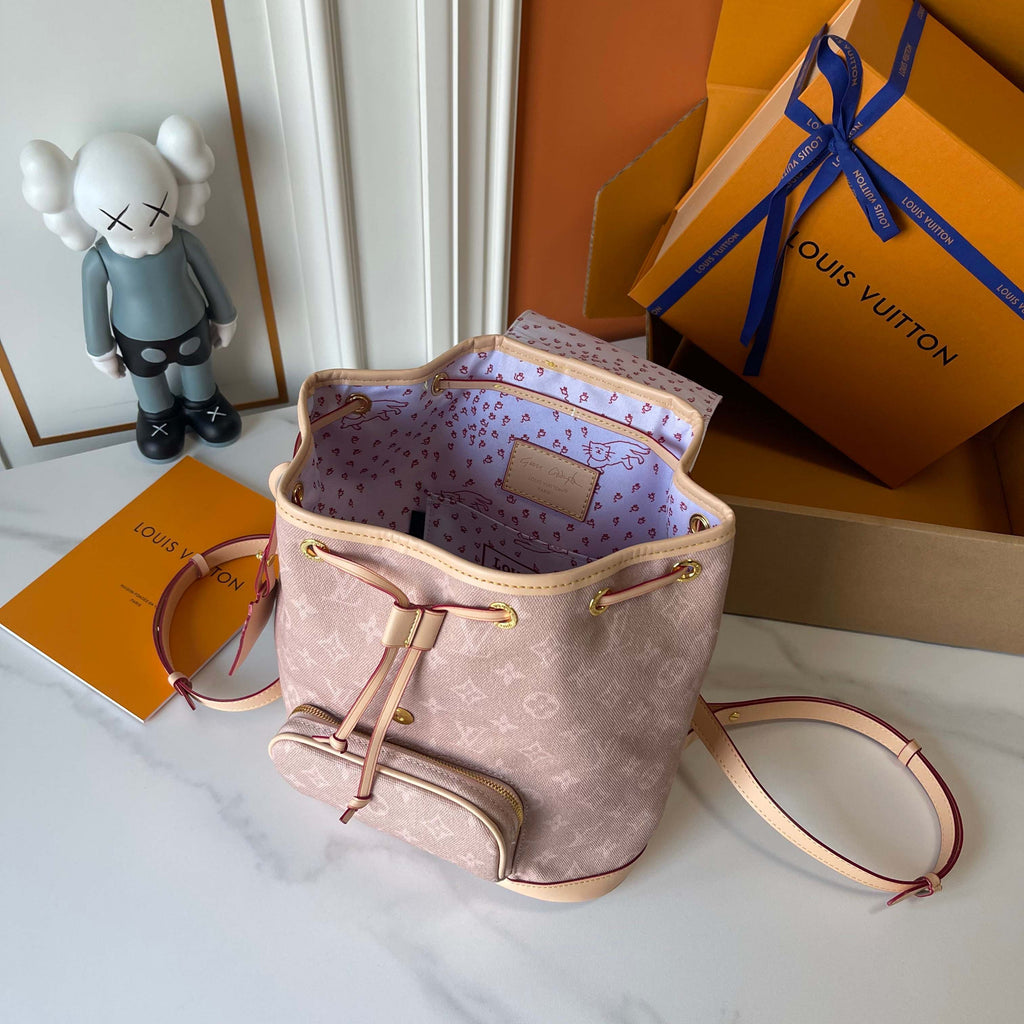 Louis Vuitton handbag with open lid showing interior, next to a branded box and toy figure.