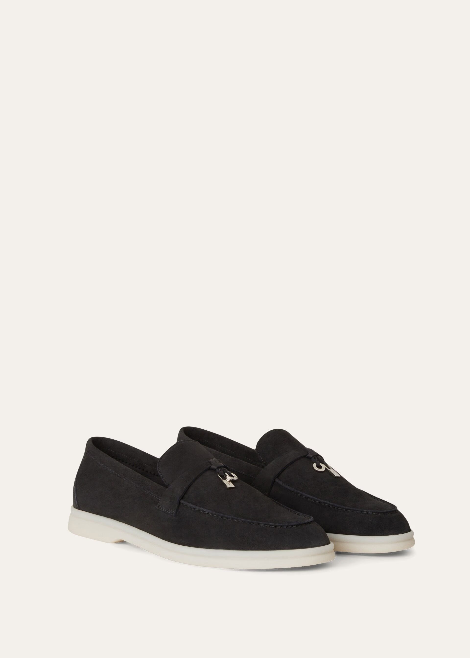 Black loafers with white soles on a light gray background