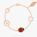 Rose gold bracelet with ladybug charm on a white background
