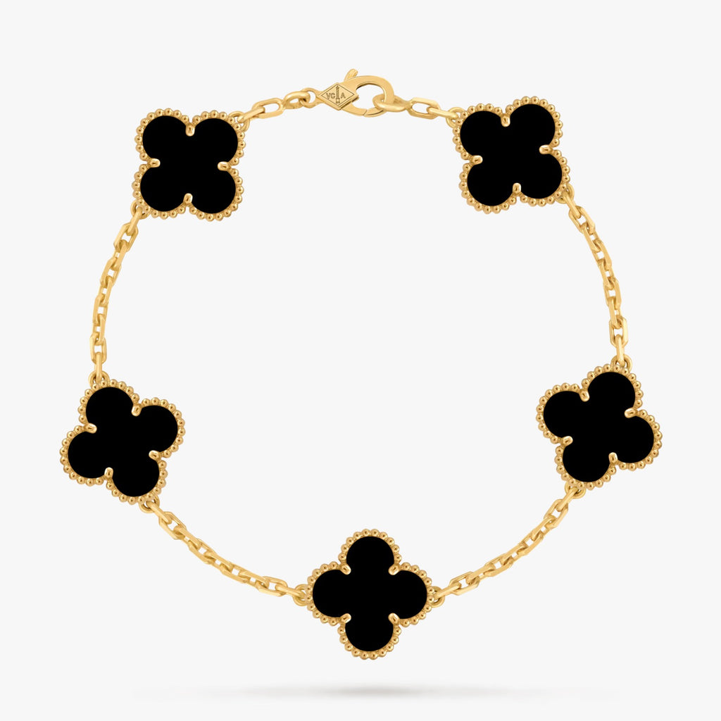 Gold bracelet with black clover-shaped charms on a white background