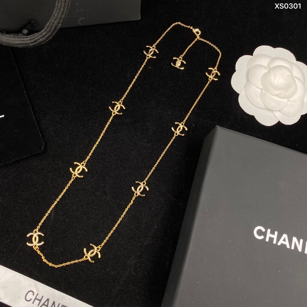 Gold necklace with Chanel logo on a black background