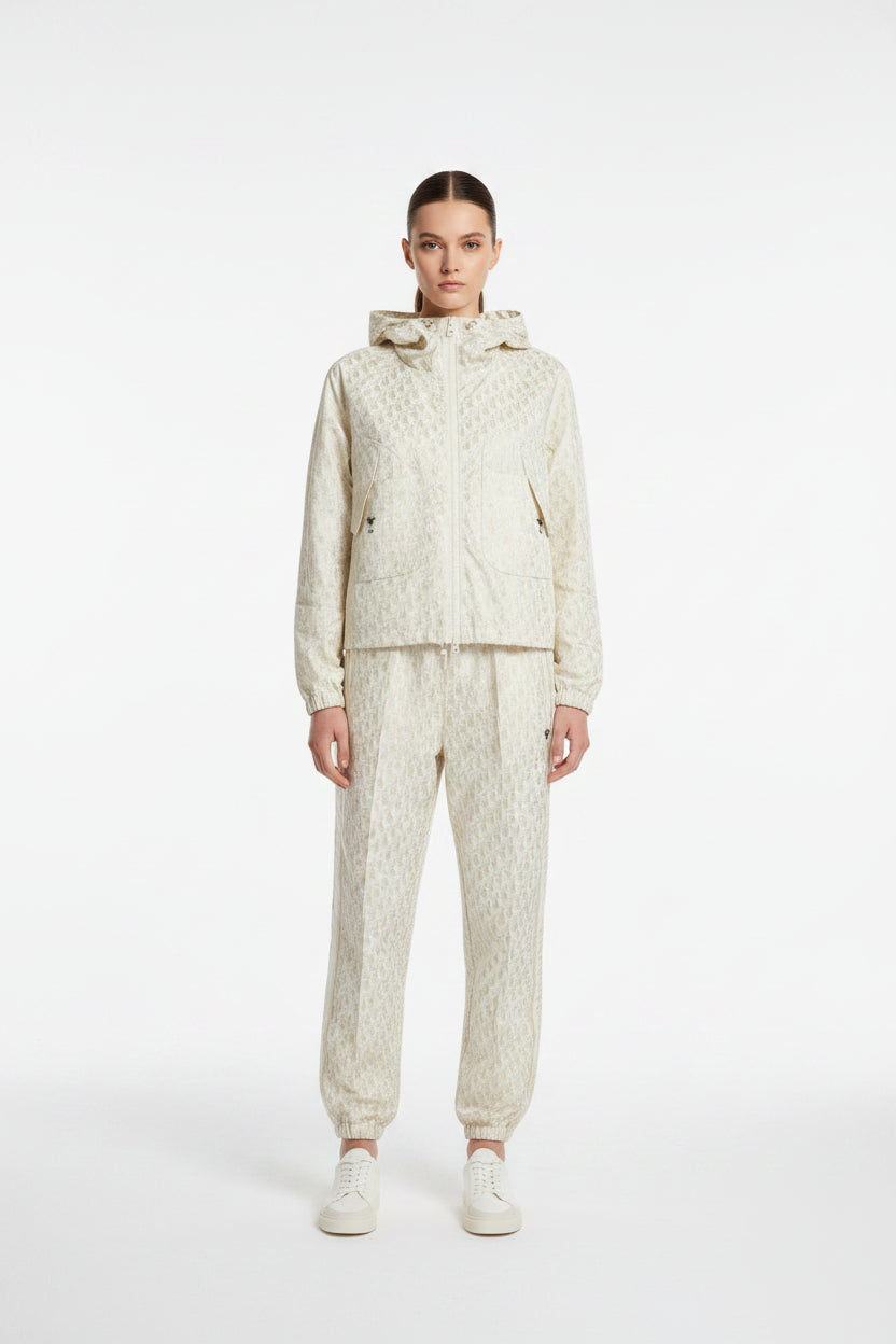 Light-colored pants and jacket on a hanger against a neutral background
